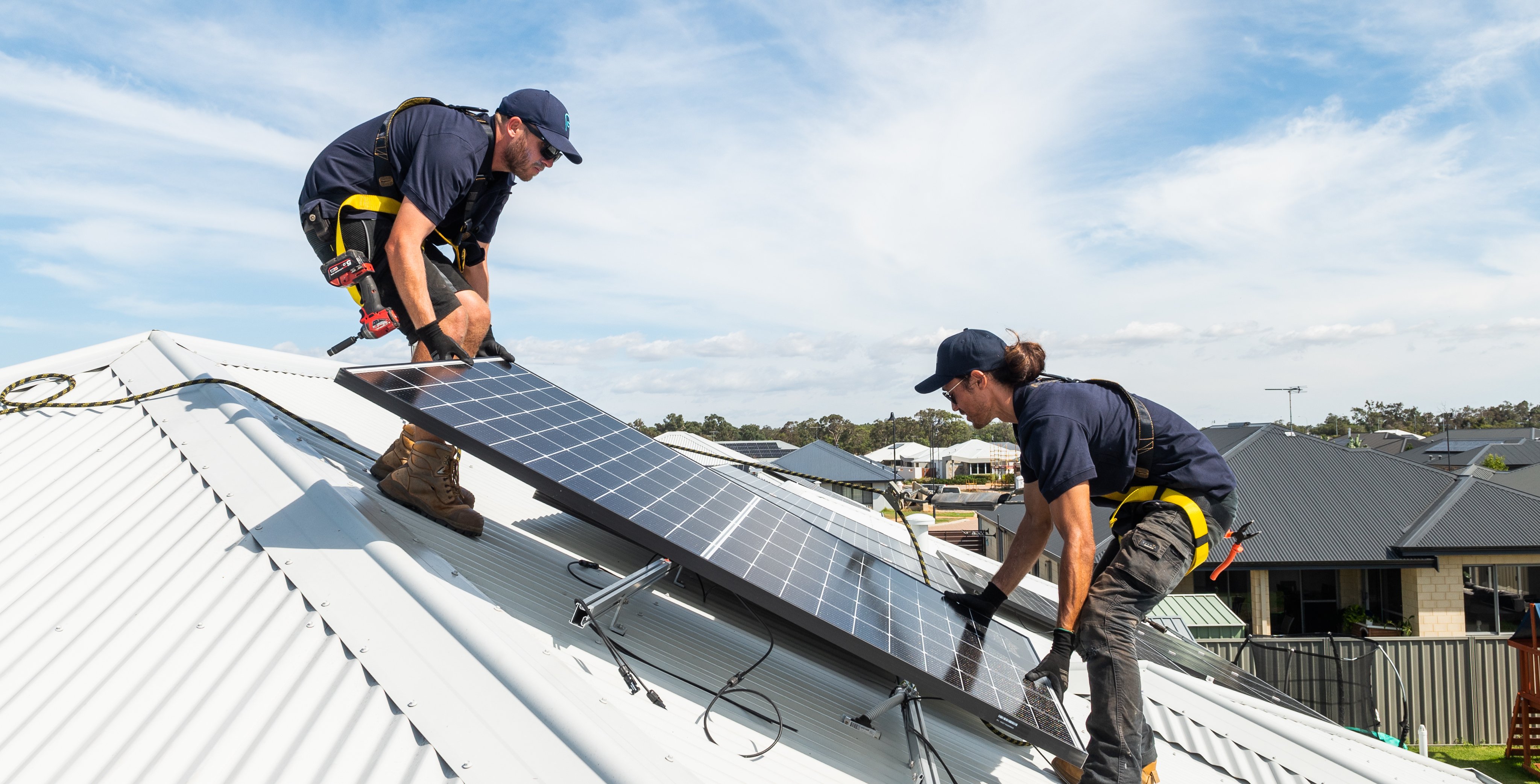 Residential solar panels being installed by two Plico workers.