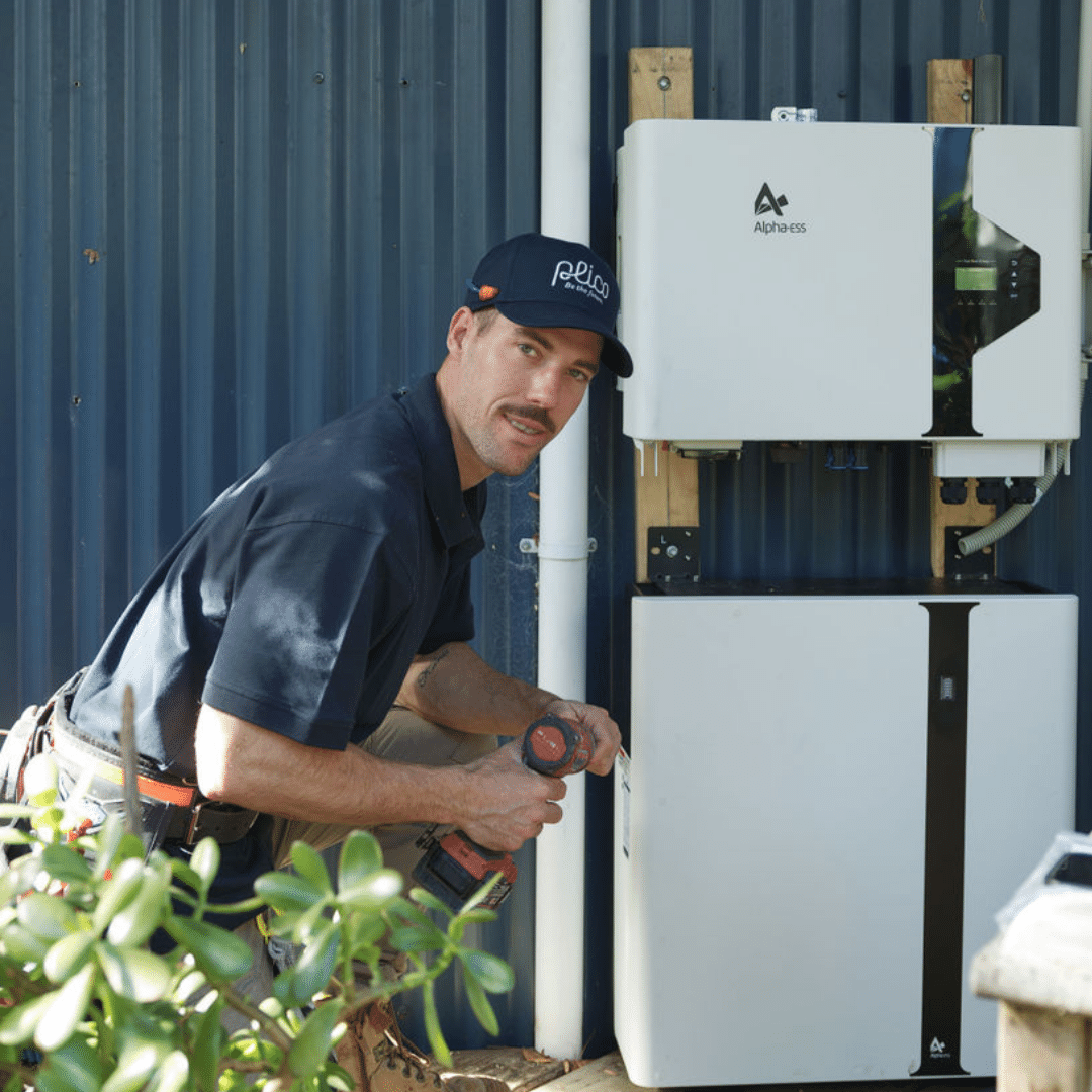 Solar system installer attaching a solar battery to a house