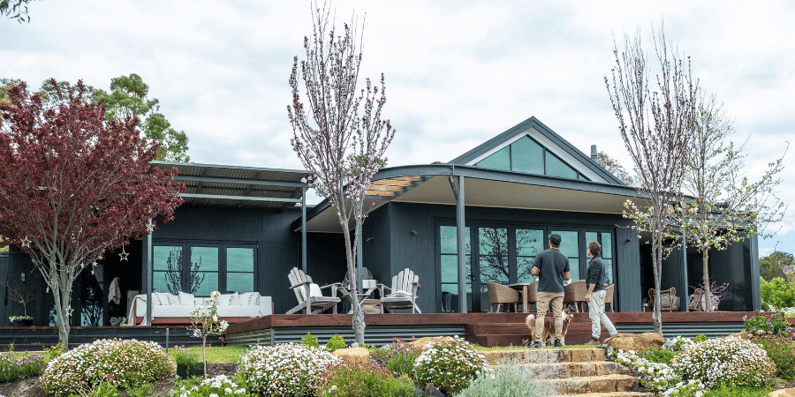 Two individuals looking from the garden at a sustainable holiday home.