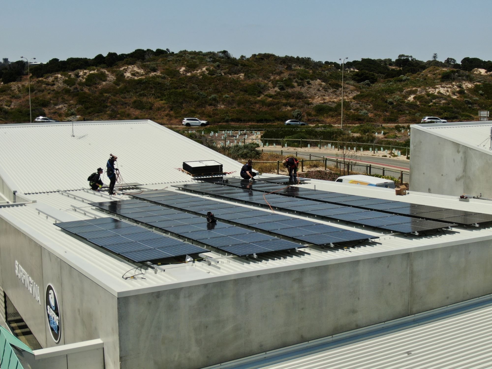 Plico staff installing solar panels on a commercial building