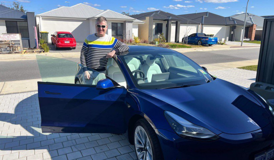 Plico member Josh standing by his Tesla electric car which he charges with this Plico solar + battery system.