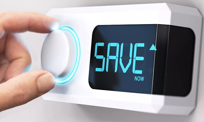 Hand turning dial on white device that says save now on the screen