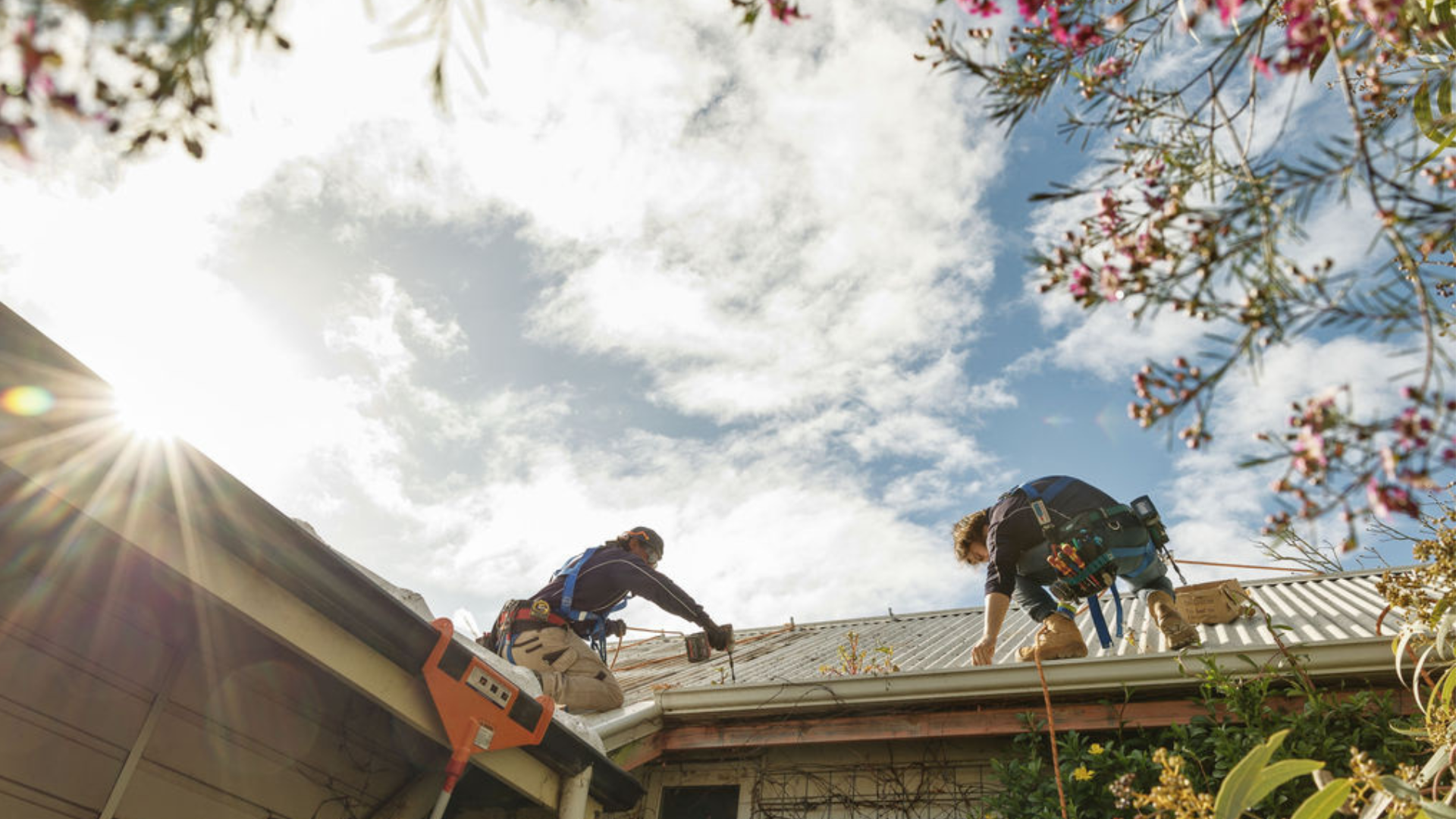 Two solar system installers working on a roof