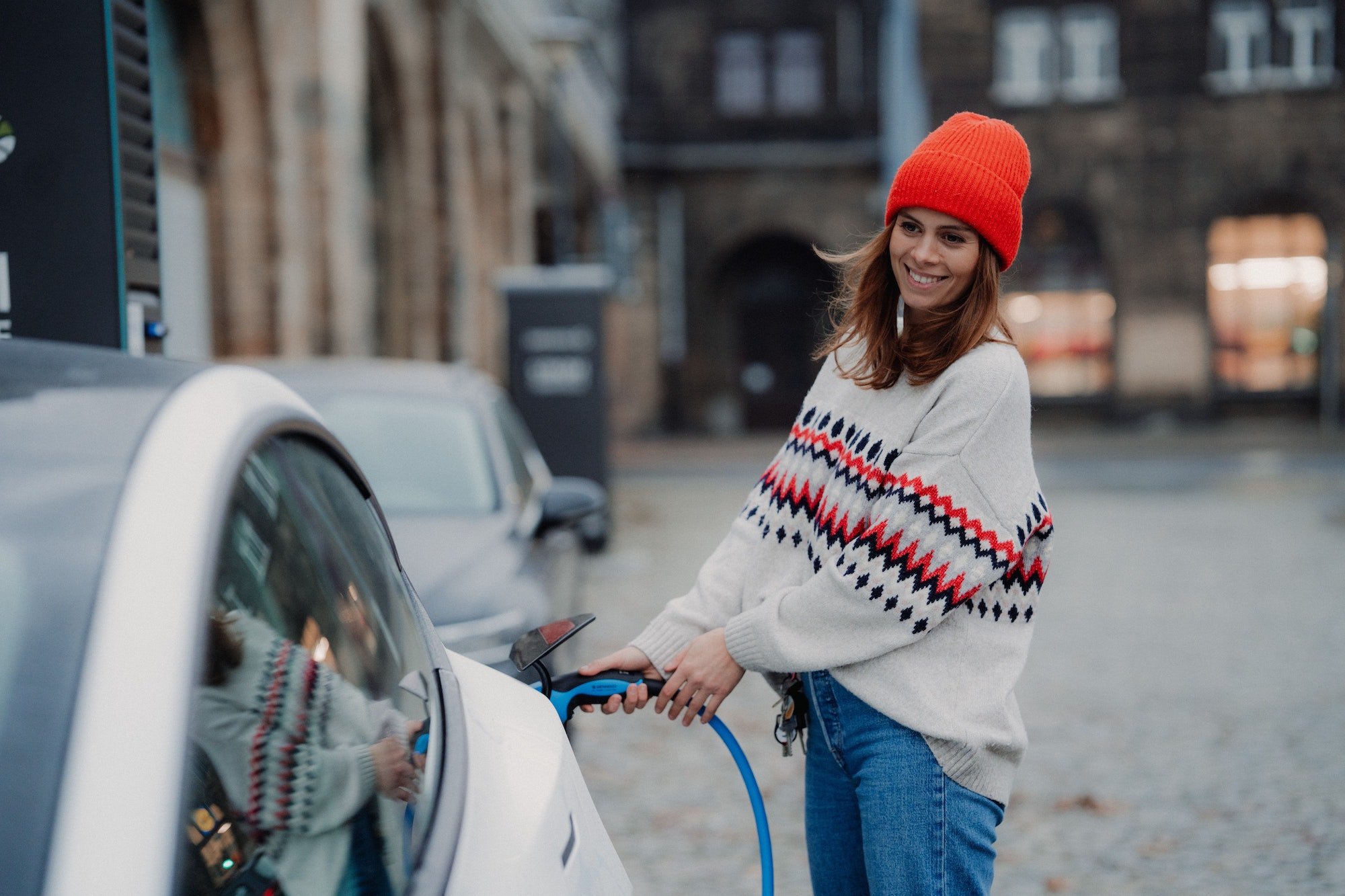 Woman charging her electric car with a public level 3 charger.